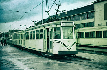 De tram onderweg. Op de achtergrond een oudere aanhangwagen.