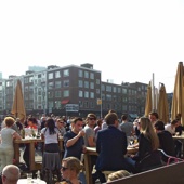 Terrasdrukte op de Binnenrotte. Hier liep ooit de spoorlijn over een viaduct, net zoals tot voor kort in Delft.